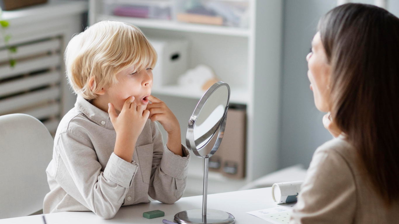 Menino fazendo exercícios de fala com fonoaudióloga infantil