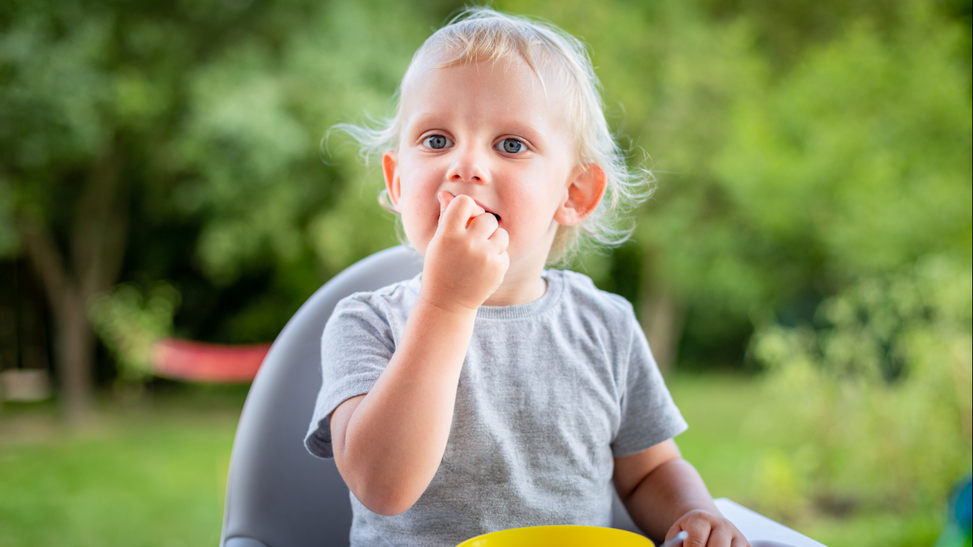 Criança no parque com dificuldade para mastigar