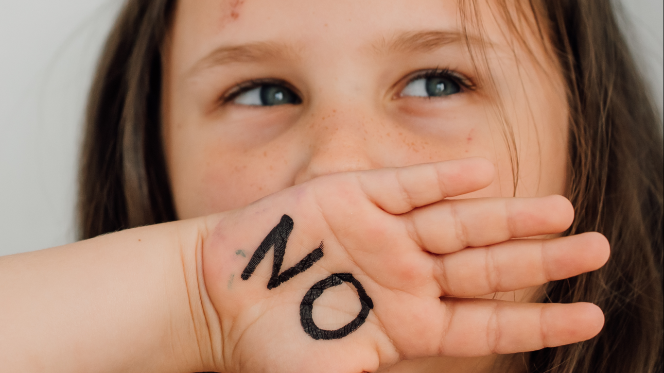 Menina com a mão na boca, para falar sobre a criança que entende mas não fala