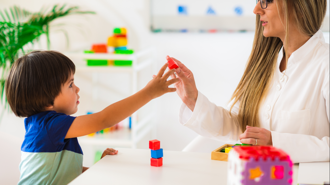 Profisisonal atendendo menino, para falar sobre como a fonoaudiologia ajuda no autismo